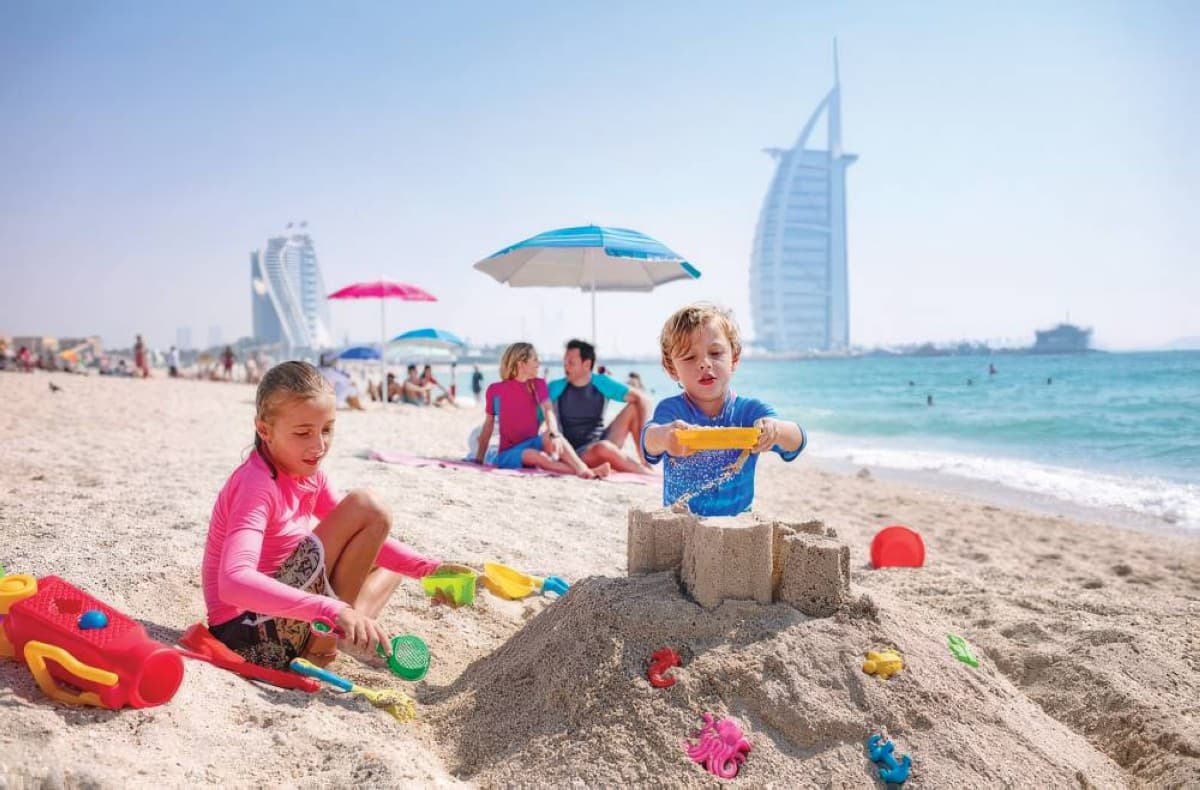 A luxury beachfront resort in Dubai during the Eid Al Adha holiday, with families enjoying the pool and waterfront facilities.