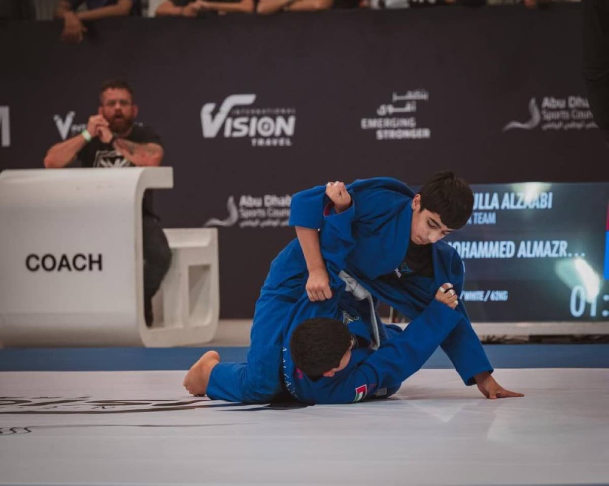 Young jiu-jitsu athletes competing on the mat at Mubadala Arena in Abu Dhabi during the UAE National Jiu-Jitsu Championship.