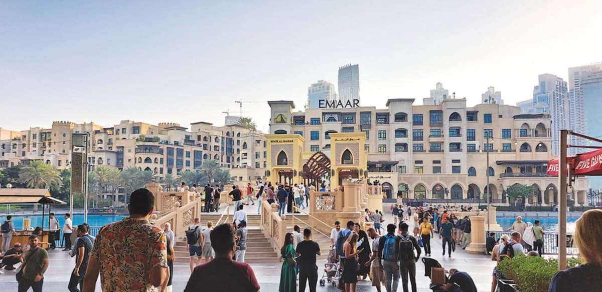 A luxury five-star resort on Palm Jumeirah in Dubai with pools and recreational facilities bustling with weekend visitors.