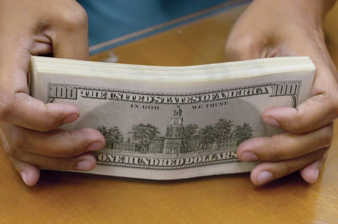 Currency trading screens displaying the dollar exchange rate near a ten-day low amid market movements following the Iran war ceasefire agreement.