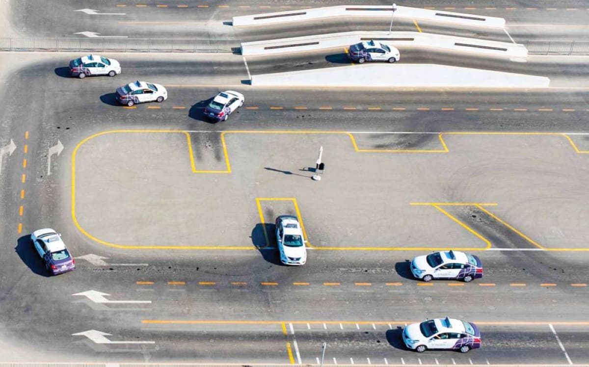 A driving institute in Dubai with vehicles lined up outside, reflecting the RTA's expanded licensing initiative across new residential areas.