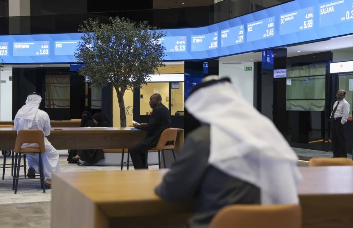 A digital display board showing the Dubai Financial Market index rising near the 6,200-point level.
