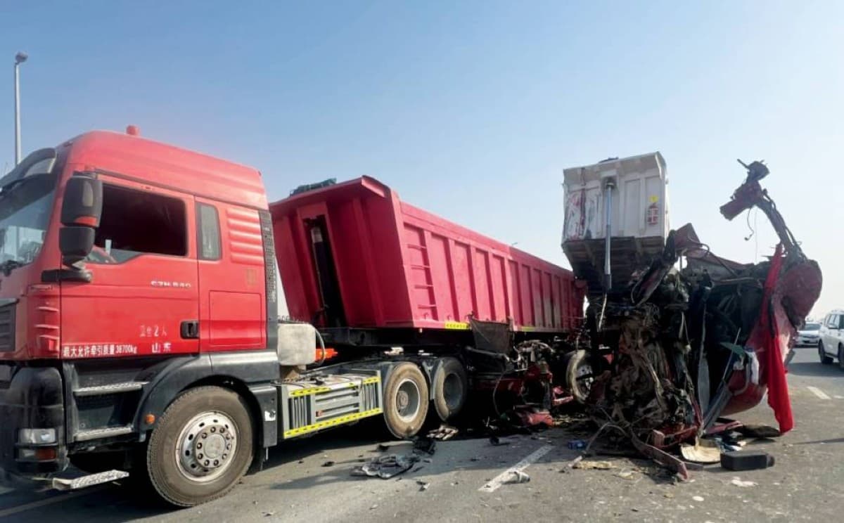 Two trucks involved in a collision on the road beyond Global Village in the direction of Sharjah, with Dubai Police traffic patrols securing the scene.