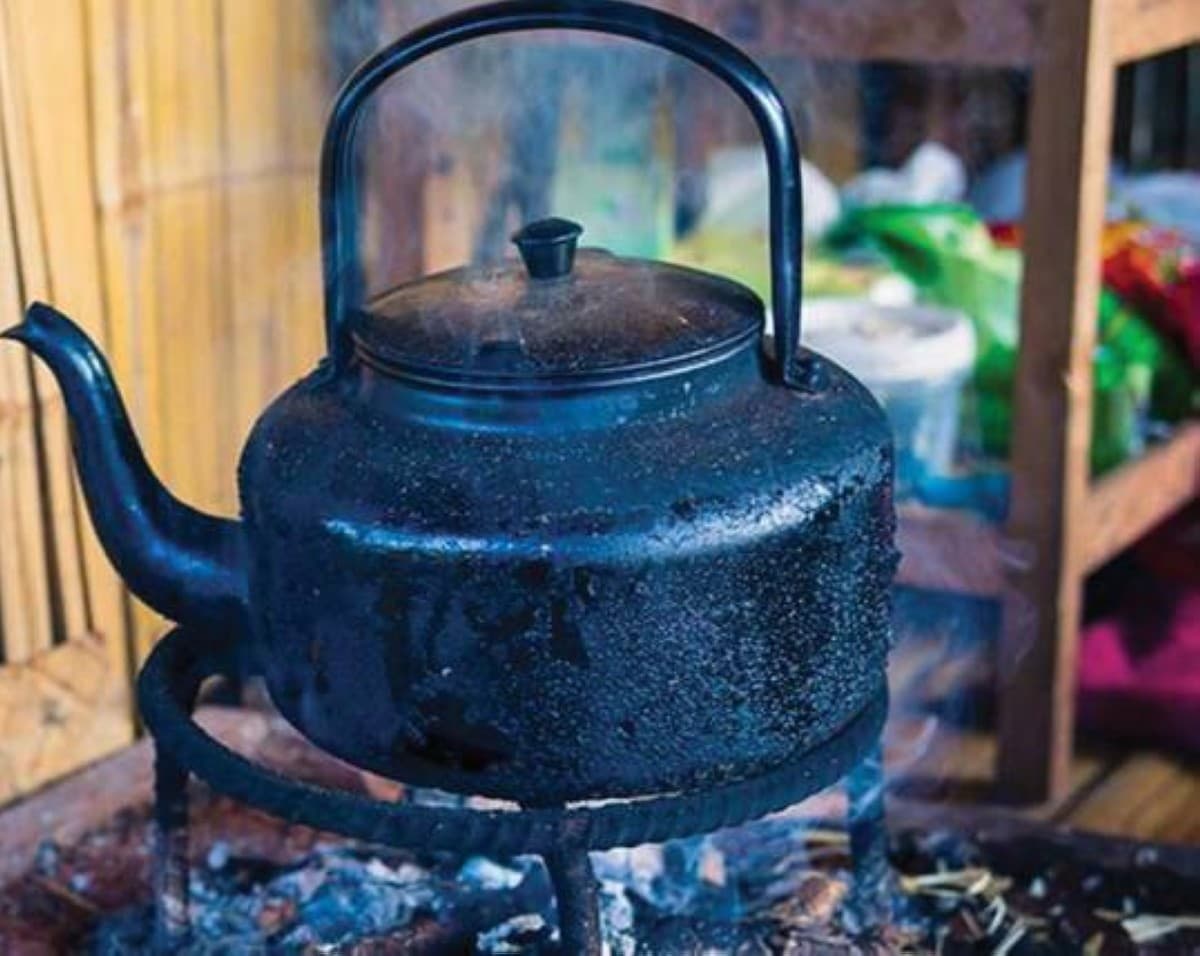A traditional Iraqi tea setting featuring small istikan glasses of dark brewed tea alongside a teapot, evoking the cultural heritage explored in the article.