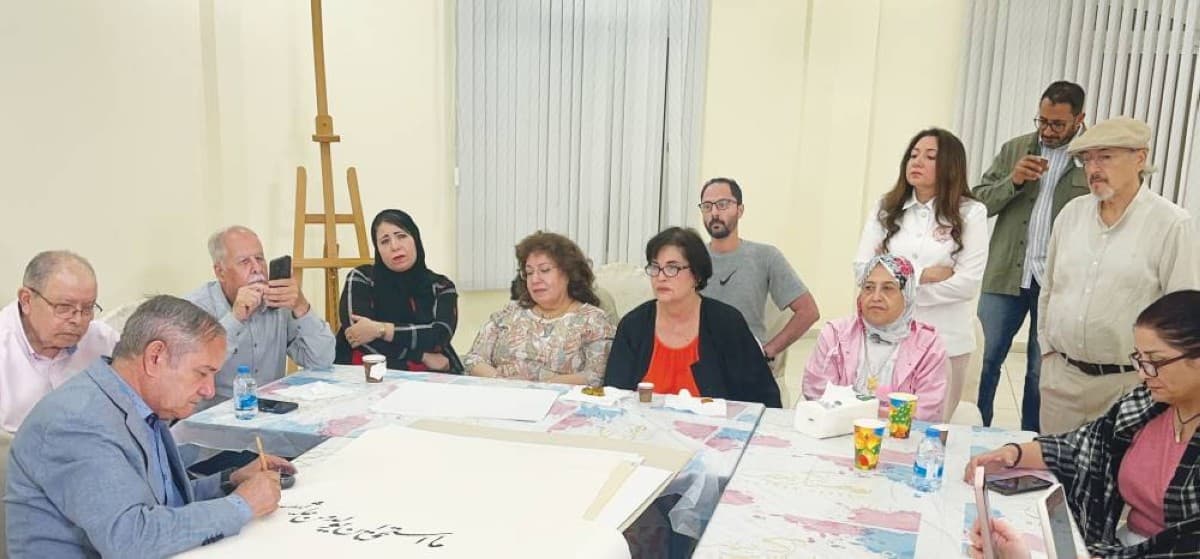 Calligrapher Khalifa Al Shaimi demonstrating Arabic calligraphy techniques during an artistic workshop organised by the Arab Cultural Club.