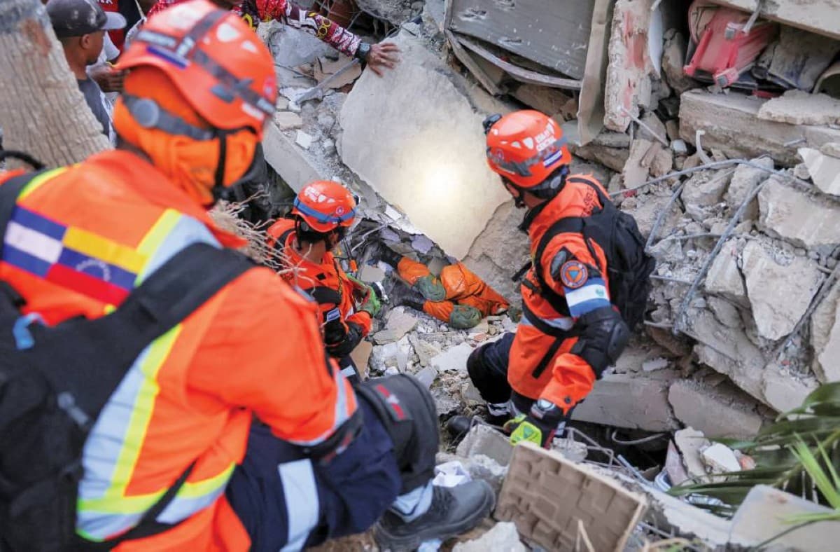 Rescue workers and residents searching through the rubble of collapsed buildings in La Guaira, Venezuela, following two powerful earthquakes.
