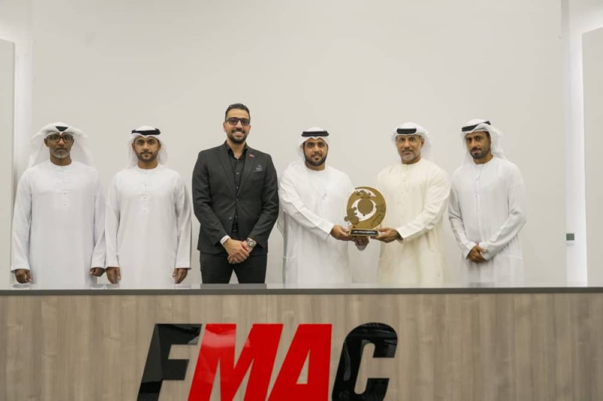 Members of Fujairah Martial Arts Club's triathlon team posing with the Overall Excellence Shield alongside UAE Triathlon Federation officials during the award ceremony at the club's headquarters.