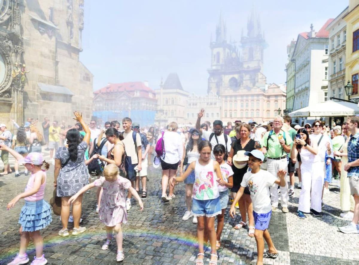 A person seeks shade during an extreme heatwave in a European city, with a thermometer visible in the sweltering summer heat.