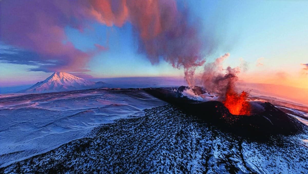 Mount Erebus volcano in Antarctica emitting gases from its lava lake crater surrounded by snow and ice.