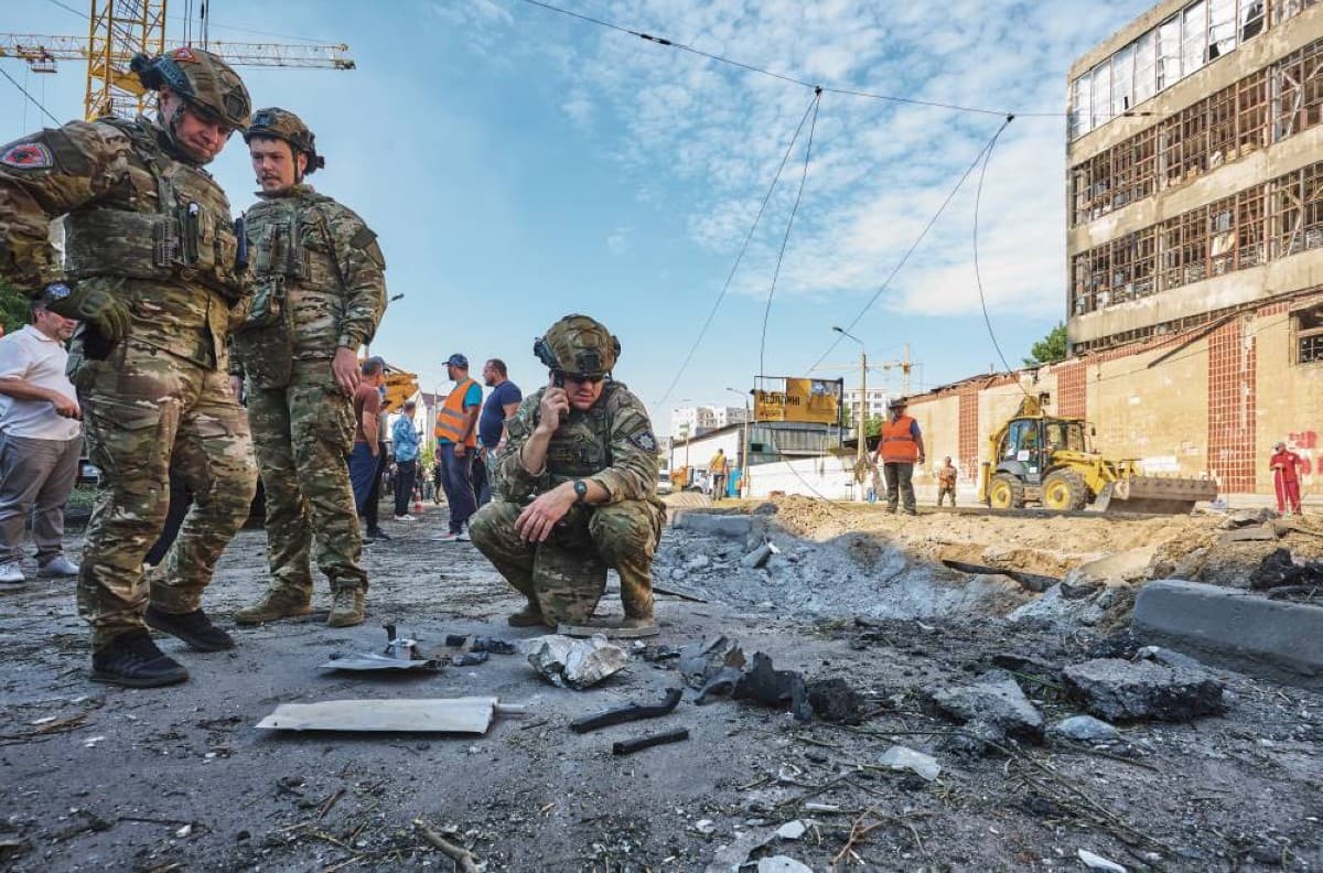 Smoke rising over a Ukrainian city following a Russian missile and drone strike, with emergency responders on the ground.
