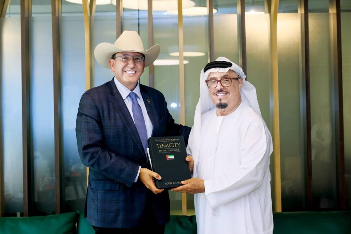 Lieutenant General Dhahi Khalfan Tamim receives a copy of the book 'Tenacity: The UAE's Finest Hour' from its author Augie K. Fabela II at the Dubai Police Officers Club.