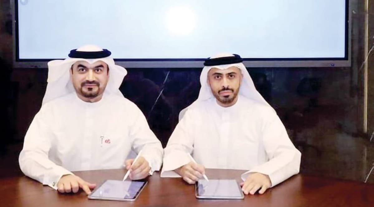 Officials from the Sheikh Zayed Housing Programme and e&amp; Group exchange a signed cooperation agreement during a formal ceremony.