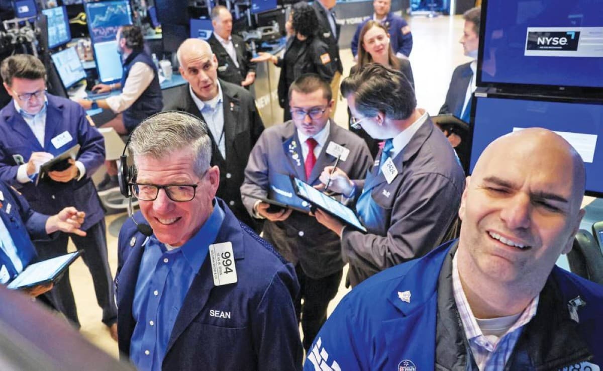 A digital display board showing green gains across major global stock market indices during a positive trading week.