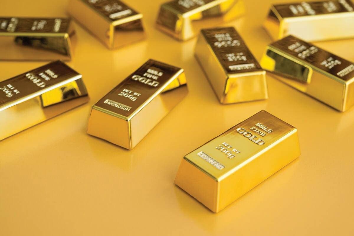 Gold bars and coins representing the precious metal whose price forecasts have been revised downward by JP Morgan.