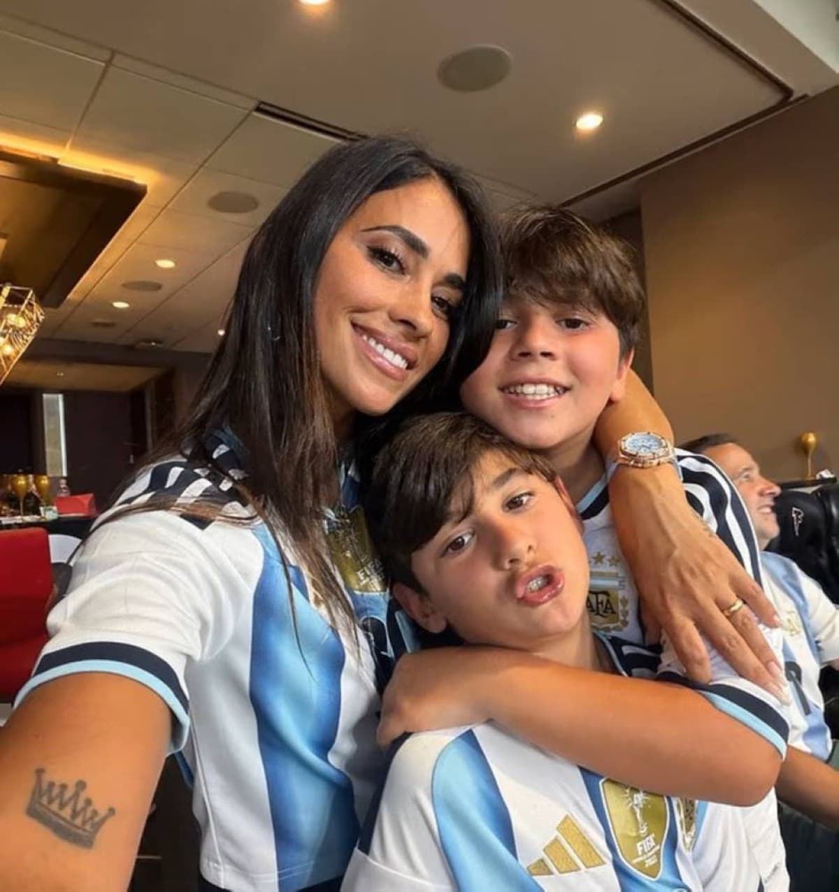 Antonela Roccuzzo and the couple's three sons in the stands at the Atlanta stadium wearing Argentina national team shirts during the World Cup round-of-16 match against Egypt.