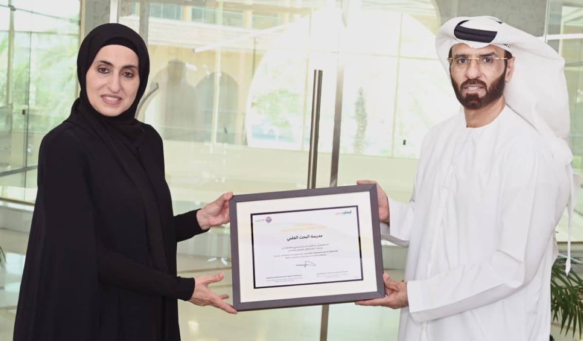 Najla Saif Al Shamsi receiving a certificate of appreciation on behalf of Al Bahth Al Ilmi Schools from the Awqaf and Minors Affairs Foundation in Dubai.