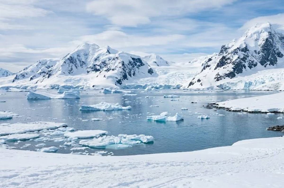 A vast expanse of Antarctica's ice sheet stretching across the white continent under an overcast sky.