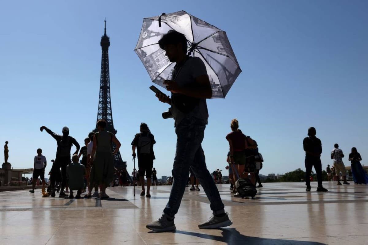 The Eiffel Tower seen during a heatwave in Paris, with a hazy sky reflecting the extreme temperatures gripping France.