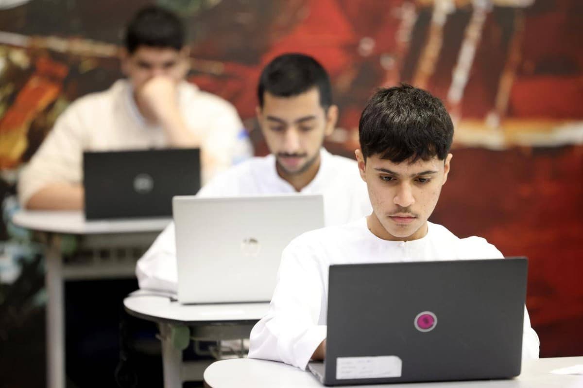 A student sits at a desk taking a written exam at a UAE government school.