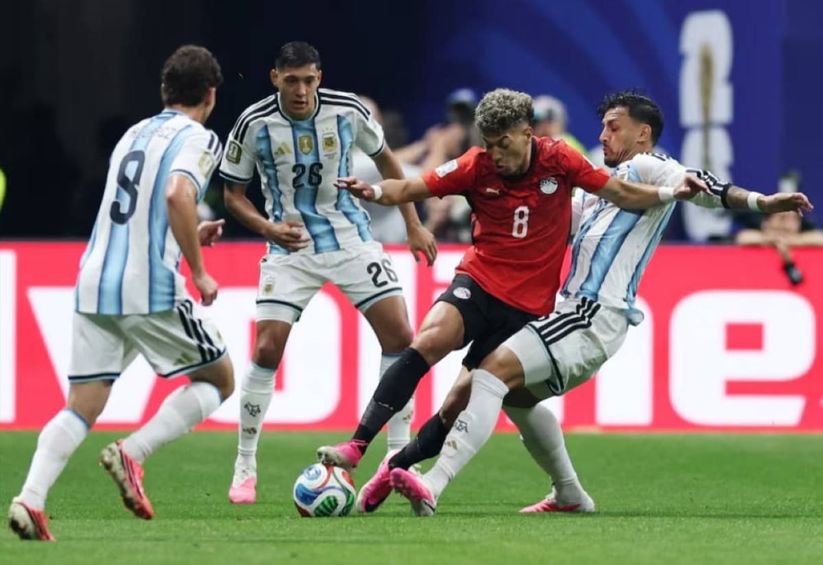 Argentina players celebrate during their World Cup knockout match, with Lionel Messi visible among the squad in their blue-and-white striped kit.
