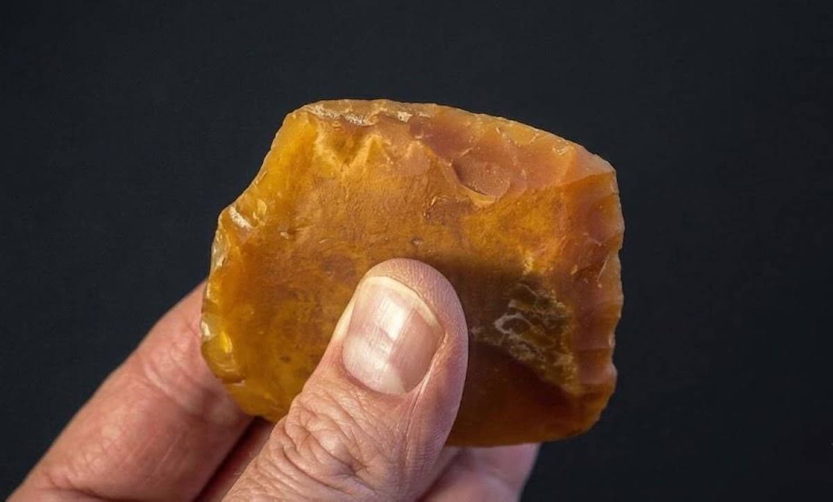 Stone tools made of orange agate discovered at the Rimrock Draw archaeological site in Oregon's mountains, buried beneath ancient volcanic ash.