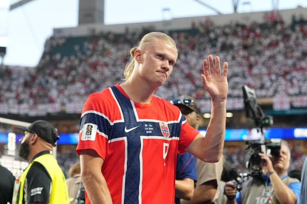 Erling Haaland holding a microphone and addressing Norwegian fans at Hard Rock Stadium in Miami after Norway's quarter-final exit from the 2026 World Cup.