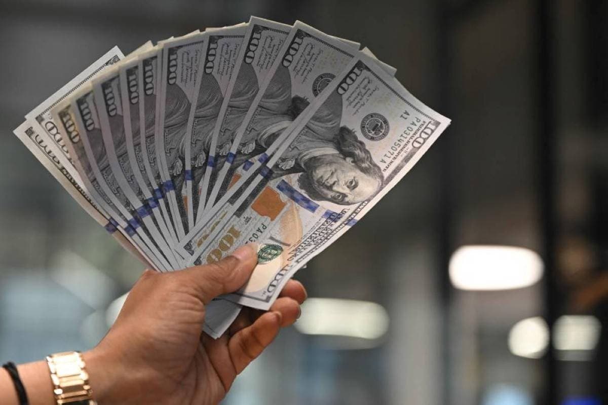 Currency trading screens displaying dollar index movements and exchange rate data amid US-Iran tensions.
