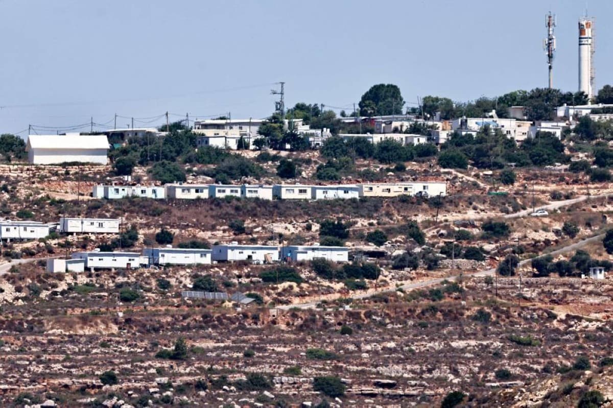Israeli settlement construction in the occupied West Bank, with clusters of new residential buildings visible on hillside terrain.