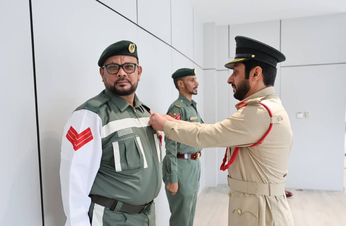 Senior Corporal Ahmed Mohammed Salem and Sergeant Omar Muslim Aflatoun receive badges of appreciation from Major General Dr. Ahmed Zaal bin Krishan Al Muhairi at a Dubai Police ceremony.