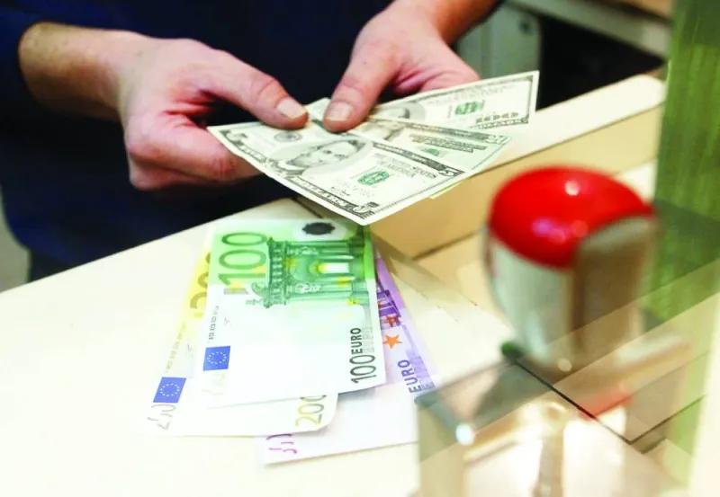 Currency trading screens displaying dollar and euro exchange rate movements.