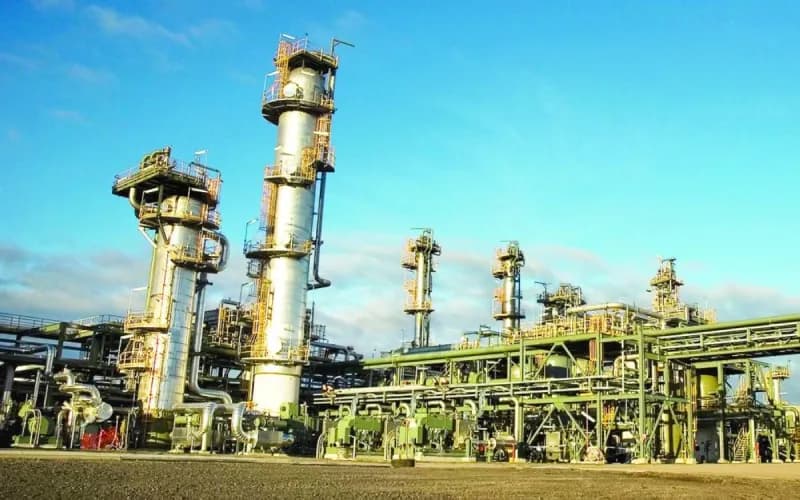 Oil storage tanks and pipelines representing falling crude prices amid US-Iran ceasefire negotiations.