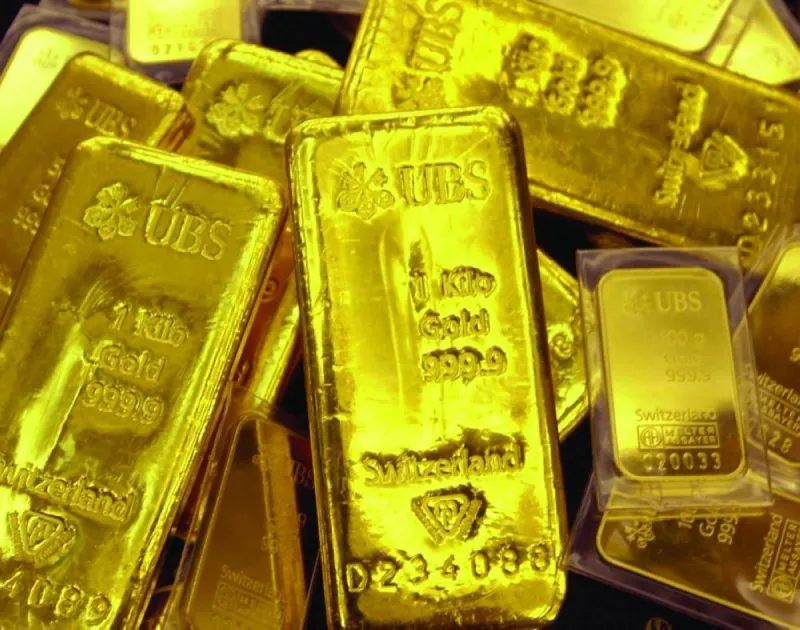 Gold bars and coins on a reflective surface, illustrating movements in global precious metals markets.