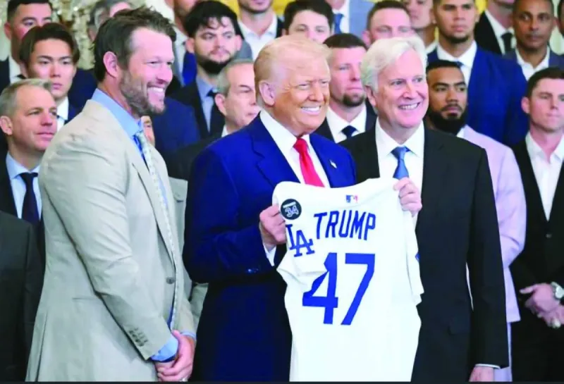 Donald Trump holds up a Los Angeles Dodgers jersey alongside pitcher Clayton Kershaw and team owner Mark Walter at a White House ceremony honouring the 2024 World Series champions.