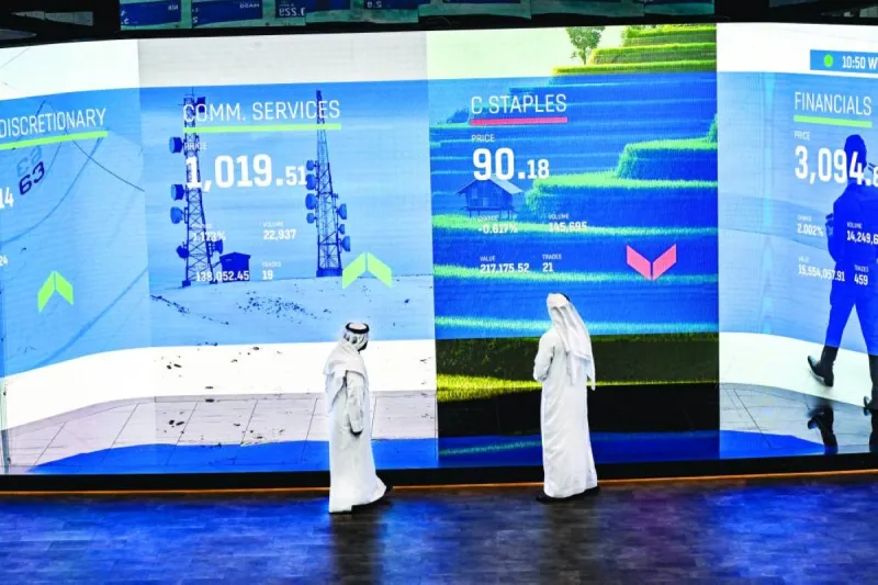 Traders monitor stock market screens displaying UAE financial market indices during a trading session.