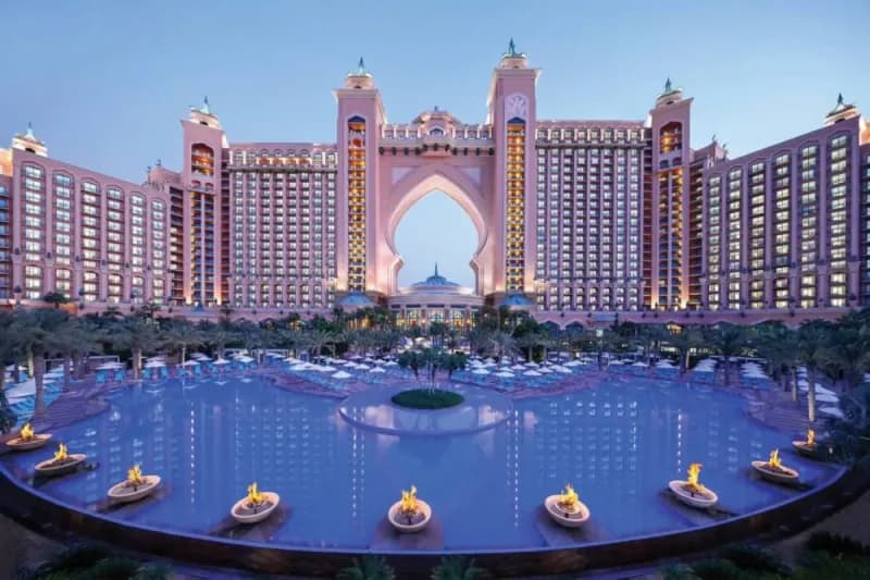 Overwater villas at a luxury Palm Jumeirah resort in Dubai, with pools and leisure facilities attracting local residents.
