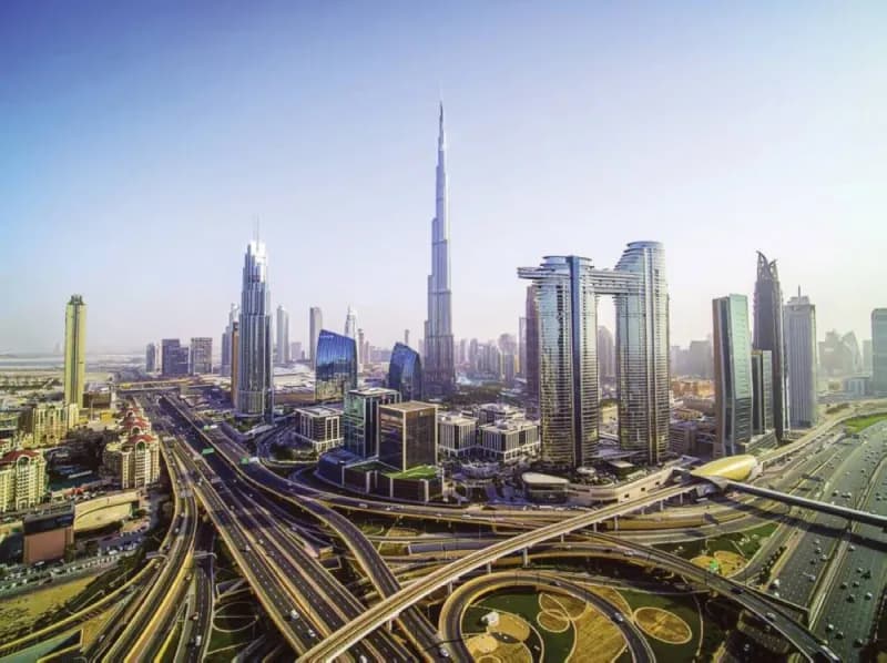 An aerial view of Dubai's multi-lane highway network stretching through the modern urban cityscape.