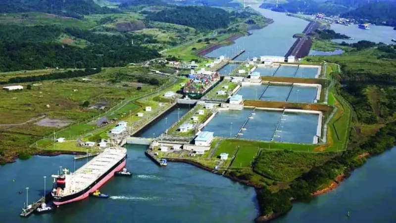 A large cargo vessel transits the Panama Canal through one of its lock chambers.
