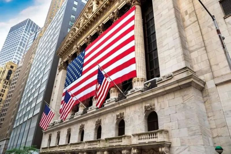 A view of the Wall Street stock exchange floor showing traders amid a session closing higher across major US indices.