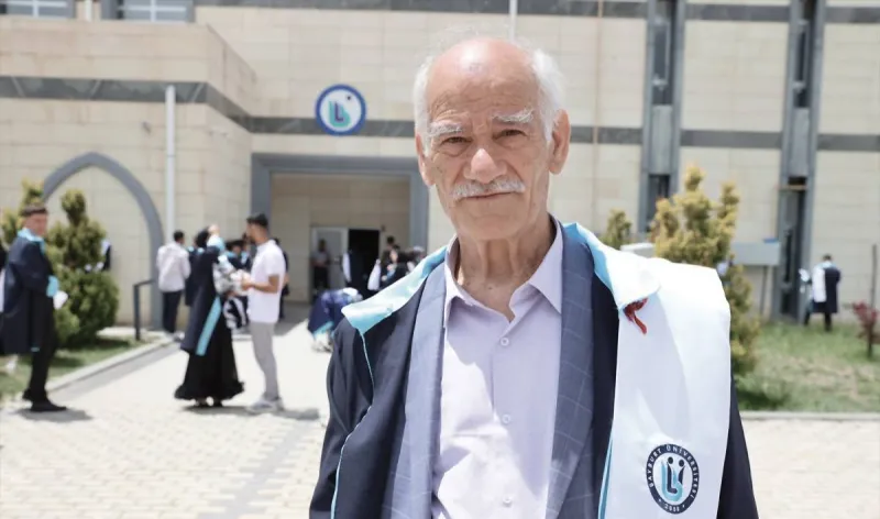 A 75-year-old Turkish man, Vasil Ceydar, stands among fellow graduates at his graduation ceremony at Bayburt University in Turkey.