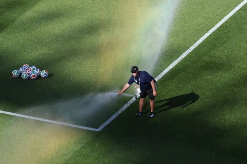 Maintenance workers attend to a malfunctioning sprinkler on the pitch at Gillette Stadium in Foxborough during the half-time interval of the Iraq vs Norway 2026 World Cup match.