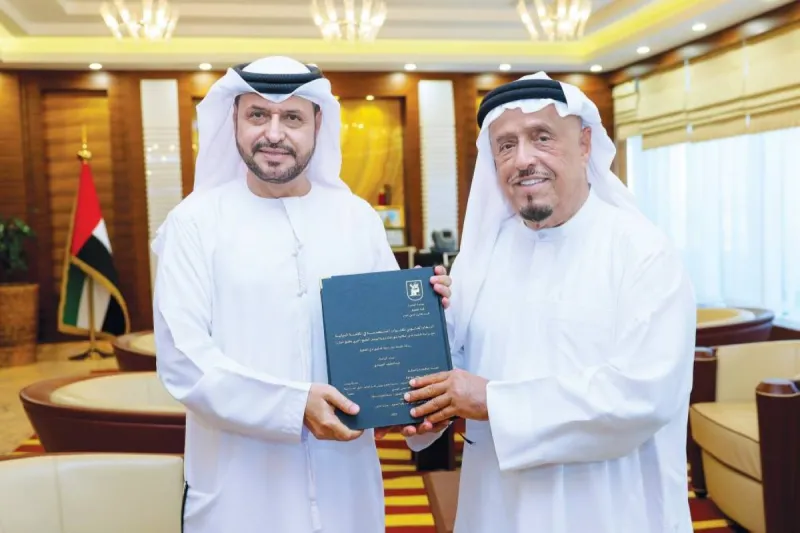 Lieutenant General Dahi Khalfan Tamim receiving a copy of the doctoral dissertation from Dr Abdul Latif Al Sayyadi at his office in Dubai.