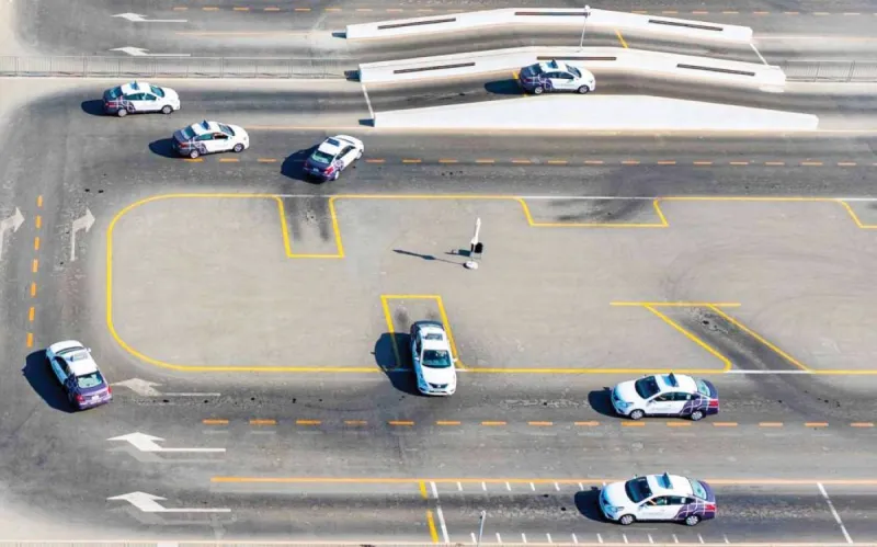 A driving institute in Dubai with vehicles lined up outside, reflecting the RTA's expanded licensing initiative across new residential areas.