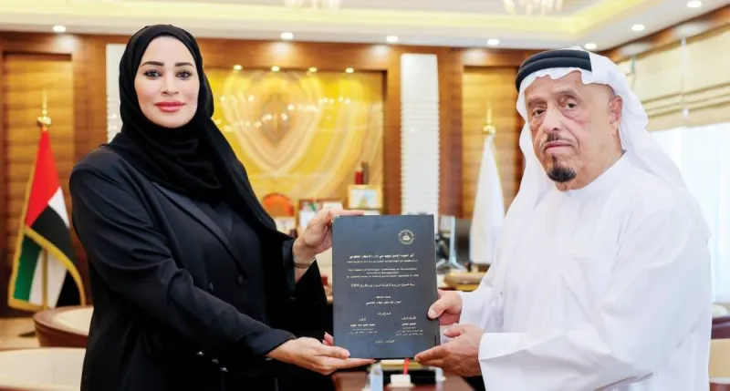 Lieutenant General Dhahi Khalfan Tamim receiving a copy of Dr. Amna Al Shamsi's doctoral thesis at his office in Dubai.