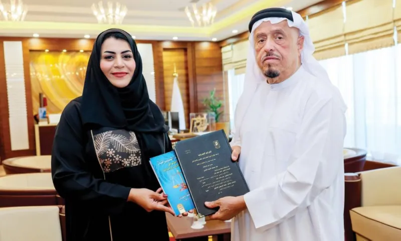 Lieutenant General Dhahi Khalfan Tamim receiving a copy of a doctoral dissertation from Dr. Ghanna Masaad Al Materi at his office in Dubai.