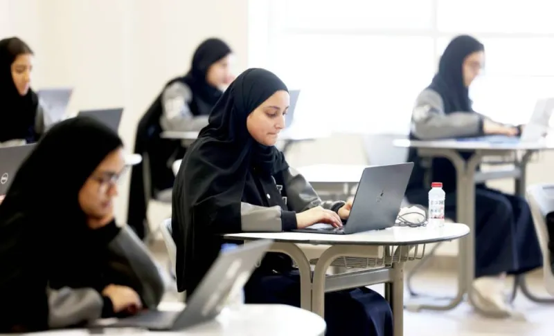 A school administrator conducts a virtual meeting with parents on screens to discuss final examination preparations.
