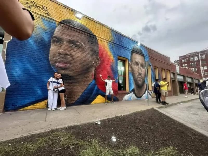 A large mural on the wall of an Ecuadorian restaurant in Kansas City depicting Ecuador and Paris Saint-Germain defender Willian Pacho alongside Argentina legend Lionel Messi.