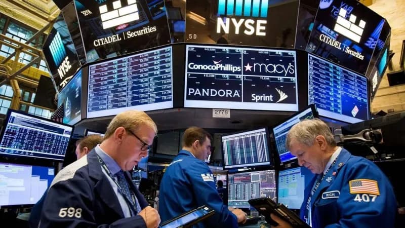 A stock market display board showing semiconductor and technology stocks trading near record highs, reflecting the AI investment boom driving Wall Street.