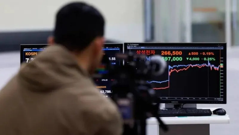A stock market display board showing rising share prices in emerging market indices, with Asian technology company logos visible in the background.
