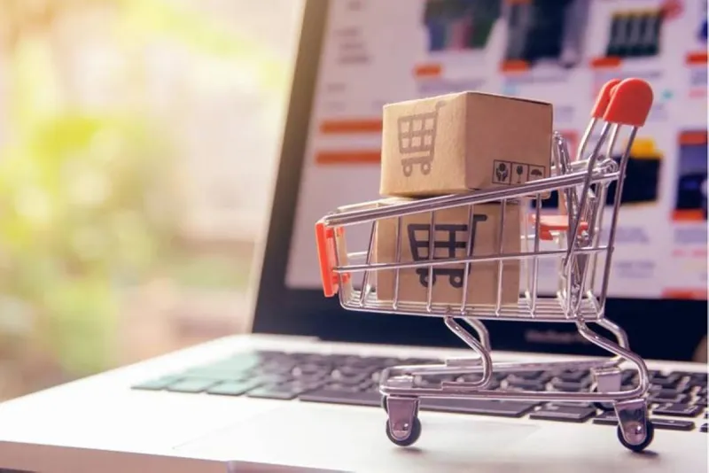 A person shopping online on a laptop, illustrating the rise of customer fraud in global e-commerce.