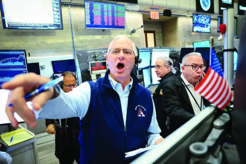 Traders monitor screens displaying global stock market data and oil prices as markets react to US-Iran diplomatic developments.